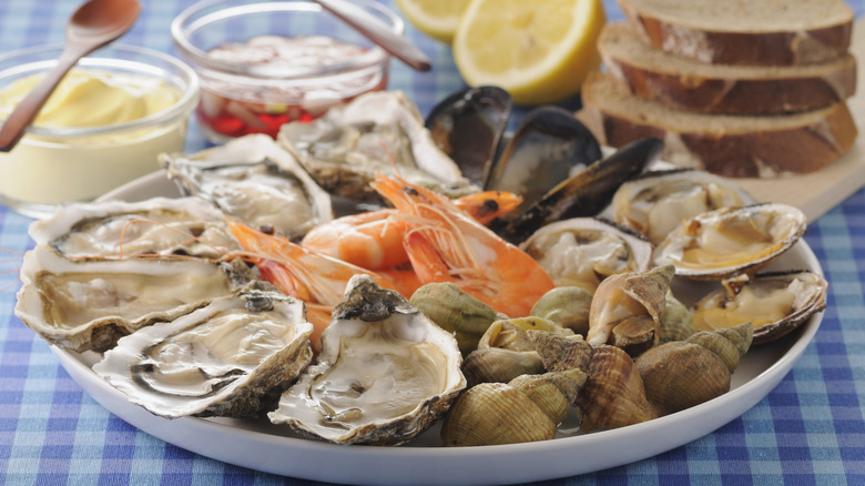 Plate of shellfish ready for eating with lemon and sauces