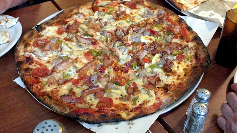 Pizza from Modern Apizza on a table with salt and pepper shakers