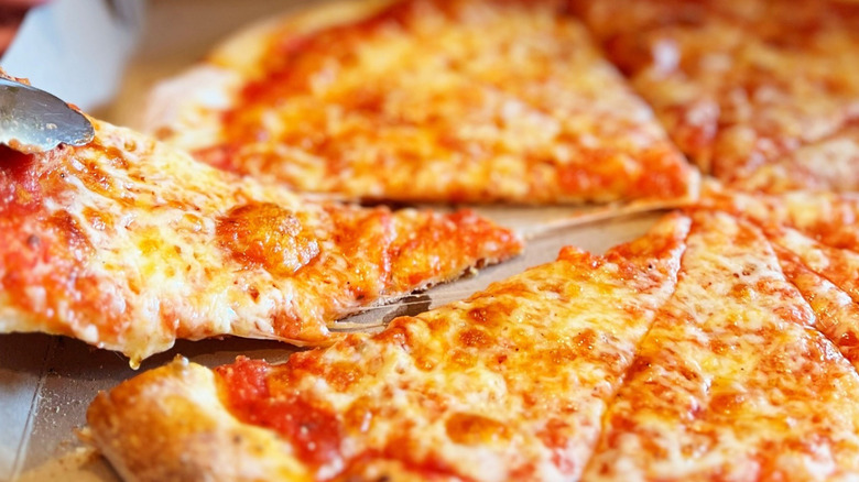 Someone slicing a pizza from Zuppardi's