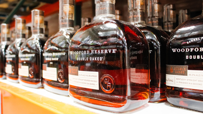 Several bottles of Woodford Reserve Double Oaked on a liquor shelf with one in center of the shot