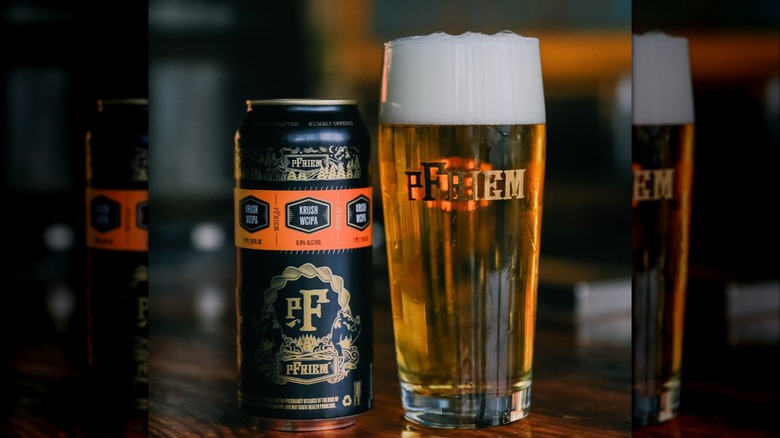 Glass and can from pFriem brewery on wooden table