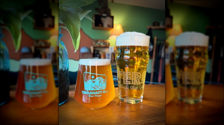 Two glasses of beer on wooden table with blurred background