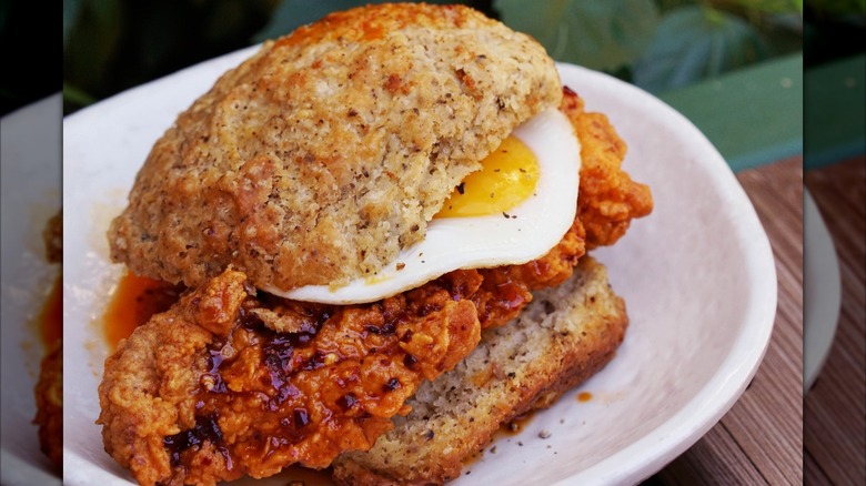 Hot and spicy fried chicken and fried egg on biscuit