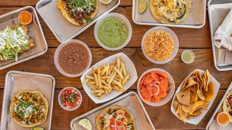 Wooden table topped with various authentic Mexican dishes