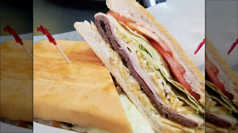 Close-up of a pan con bistec sandwich cut in half from Franky's Deli Warehouse
