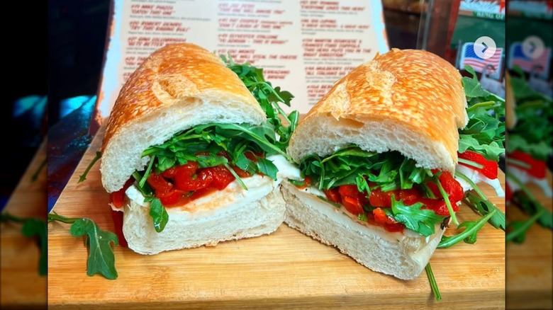 Mozzarella, tomato, and roasted pepper sandwiches placed in front of a Lioni Italian Heroes menu