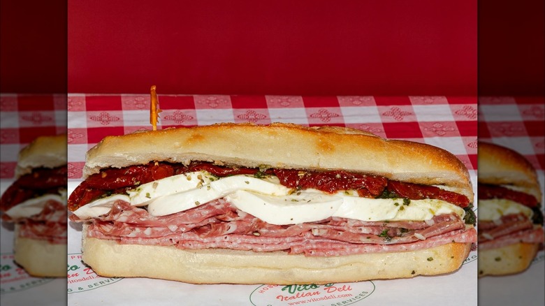 Meat, mozzarella, and sundried tomato sub from Vito's & Son Italian Deli on a red checkered tablecloth
