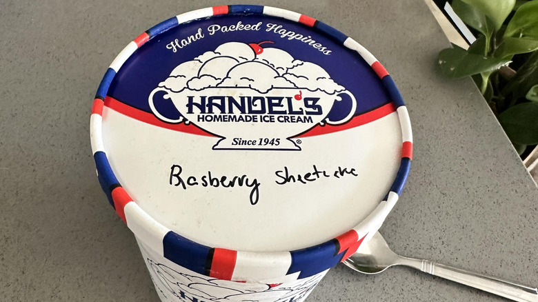 Overhead view of a red, white, and blue pint of Handel's homemade ice cream with "raspberry sheet cake" handwritten on it