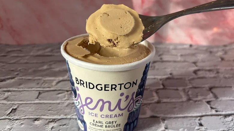 A spoonful of Bridgerton Jeni's Earl Grey Crème Brûlée Ice Cream held above an open pint