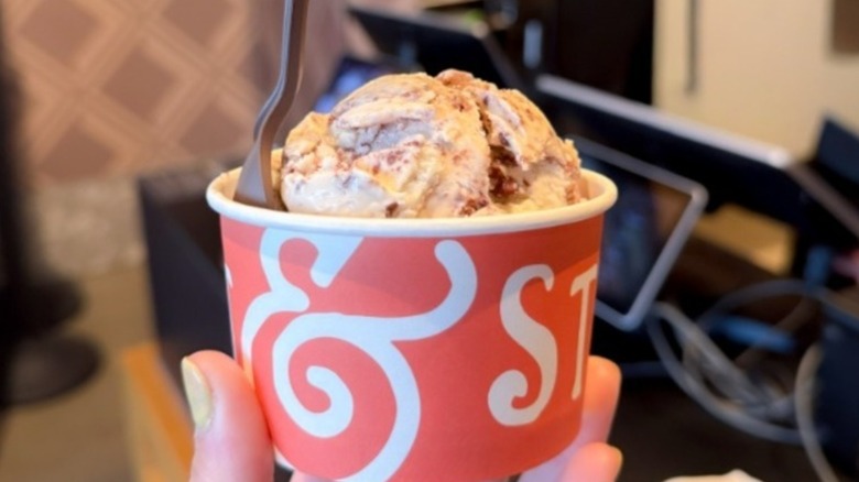 A hand holding a Salt & Straw cup of ice cream