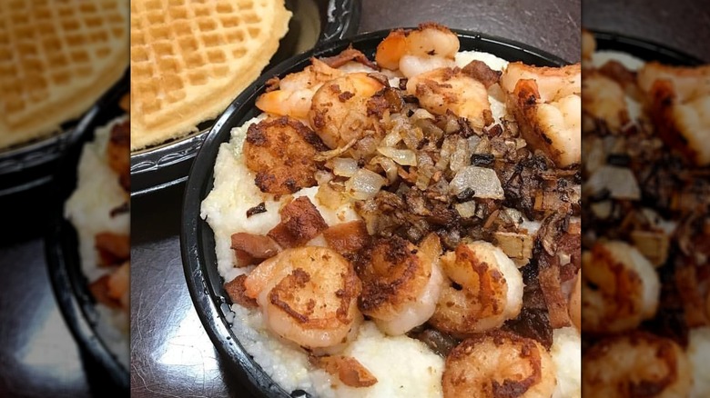 Shrimp and grits with plate of waffleson the side