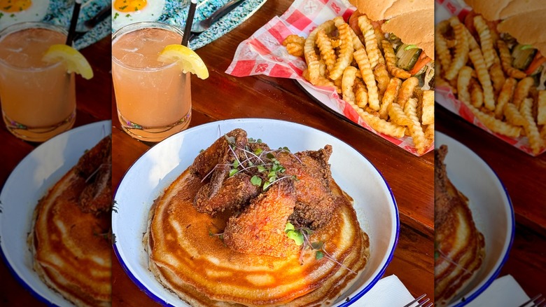 Fried chicken on pancakes with cocktail and po'boy with fries