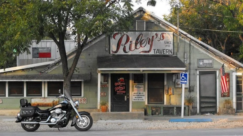 A motorcycle pulls up to Riley's Tavern