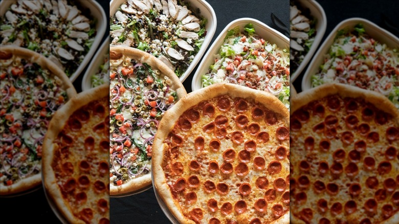 Various pies and sides from Dewey's Pizza on a table