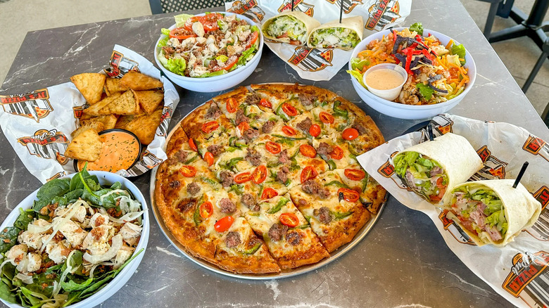 Pizza and other appetizers and entrees from JT's Pizza & Pub on a table