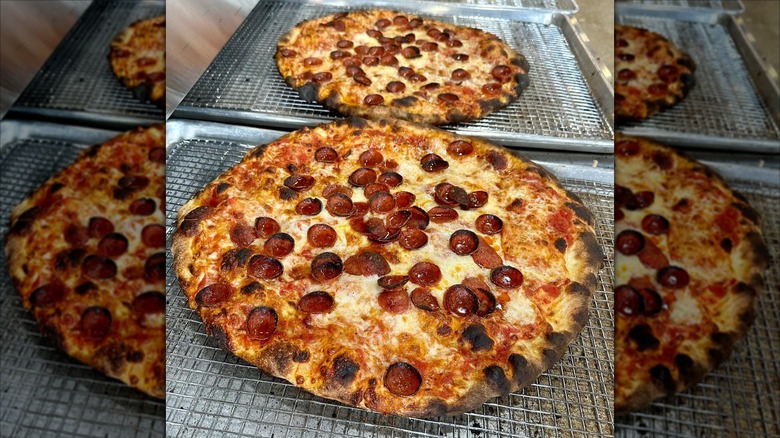 Two cheese and pepperoni pizzas with charred edges