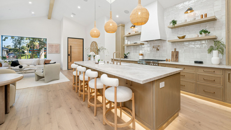 Modern kitchen interior with wooden cabinets, island, and pendant lights