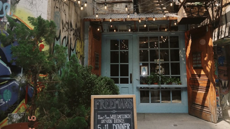The exterior blue door of Freemans in New York City