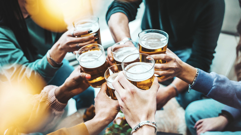 group of people clinking beer glasses