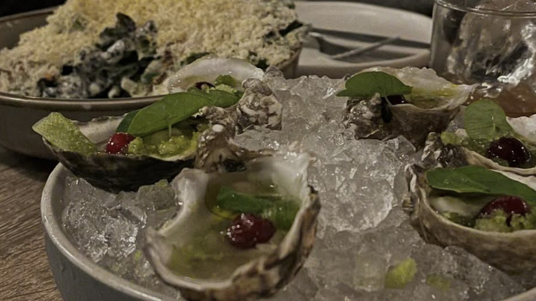Platter of oysters on ice with salad in the background
