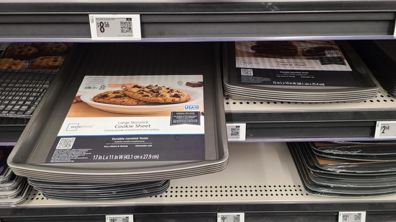 Stacks of cookie sheets on shelves.
