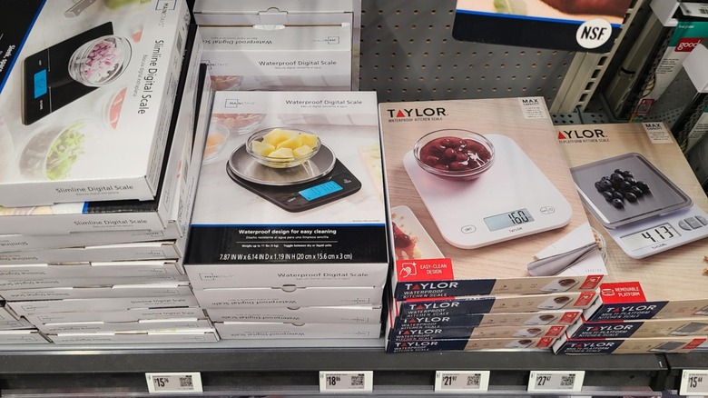 Packages of different kitchen scales on a shelf.