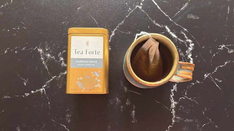 Tea Forte pumpkin spice black tea container next to cup of tea