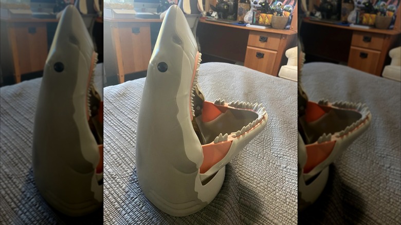 The Jaws shark-shaped popcorn bucket sits on a table with its mouth open