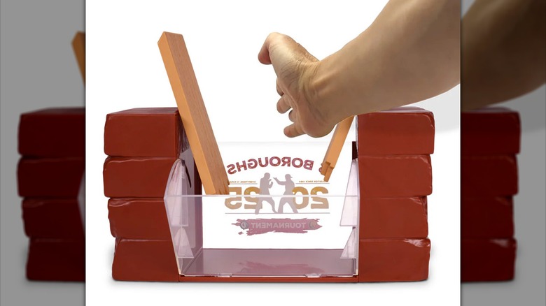 A hand chops the wood of the Karate Kid: Legends popcorn bucket