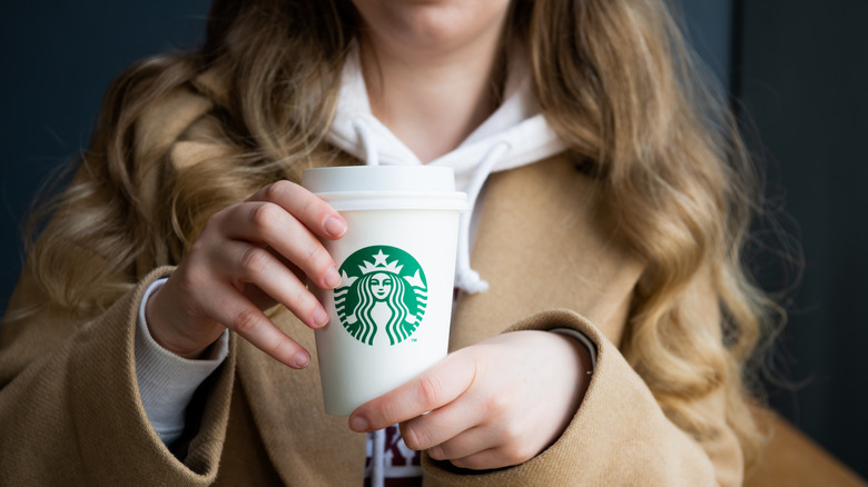 Person holding Starbucks to-go cup