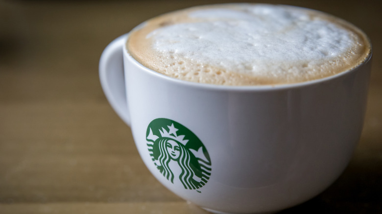 Close-up of cappuccino in white Starbucks mug