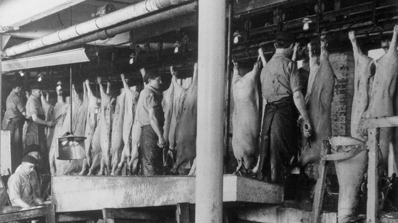 Workers inspecting meat at a meatpacking plant