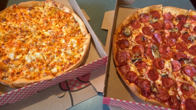 Two pizzas in cardboard boxes
