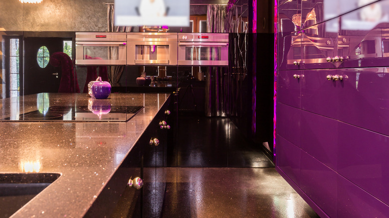Kitchen with purple neon LED strips and purple cabinets.