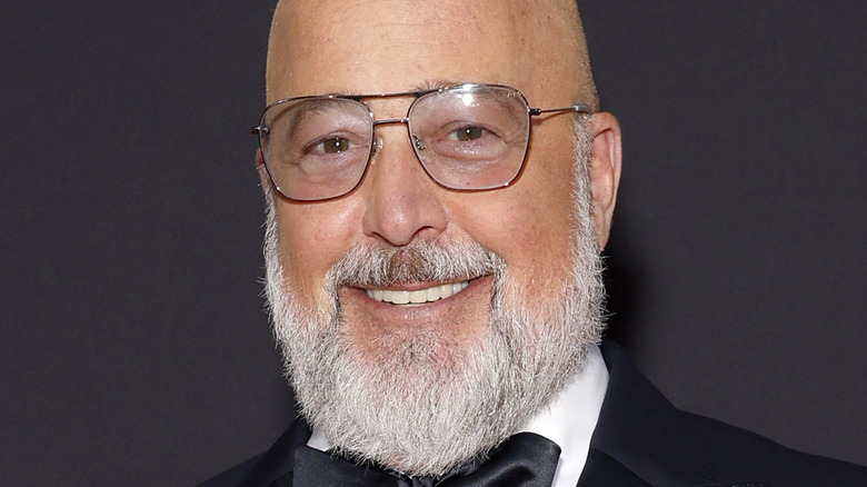 Andrew Zimmern smiles with glasses and beard