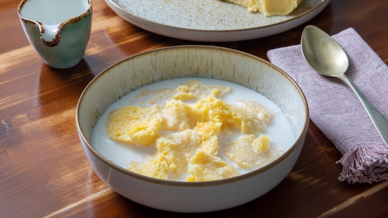 Polenta in a bowl with milk and sugar