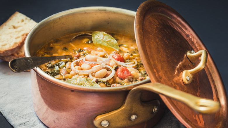 A pot of soup filled with various vegetables