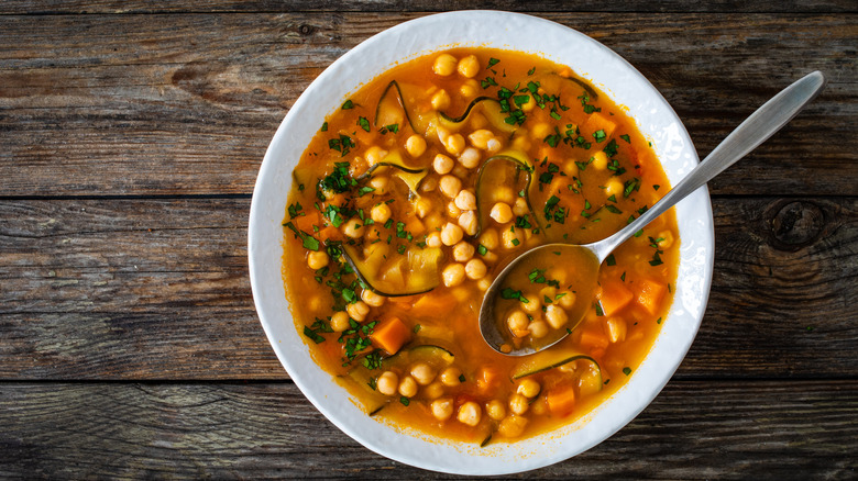 A bowl of chickpea soup on a wooden table