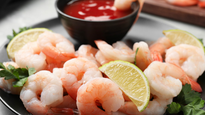 Pieces of shrimp with cocktail sauce on plate
