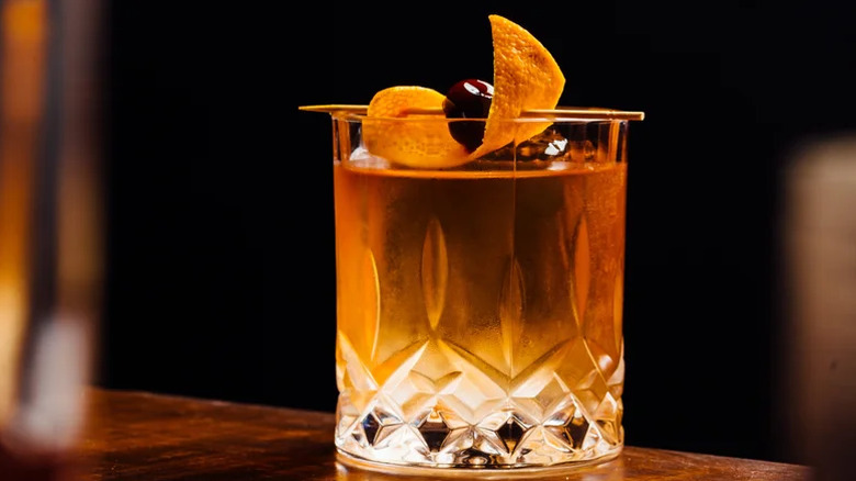 An old fashioned cocktail with a dark backdrop