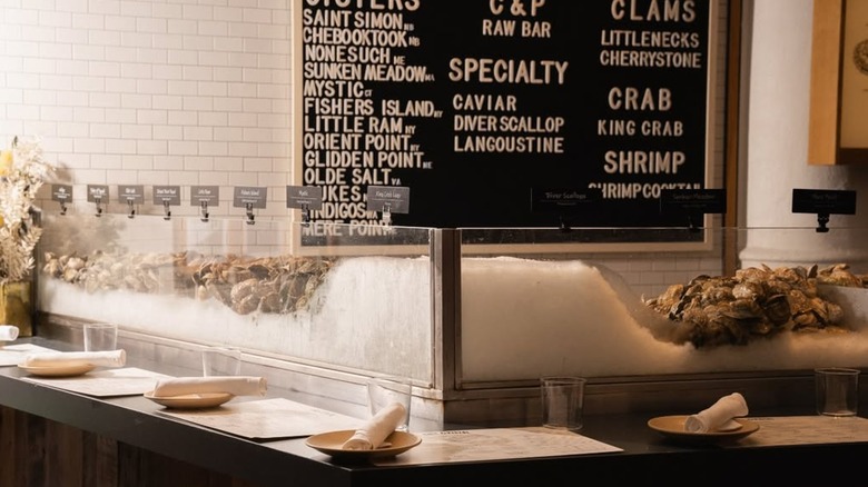 A glass bar loaded with ice with a black and white menu in the back