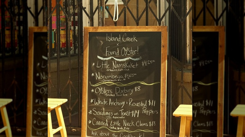 A chalkboard listing different oyster prices