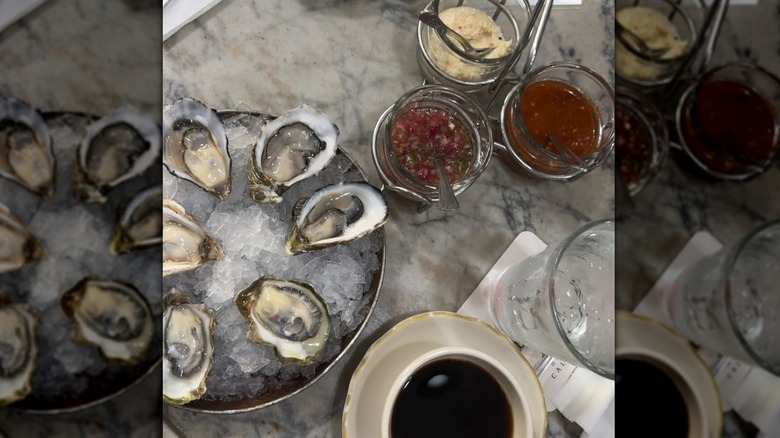 Oysters next to a cup of coffee and garnishes in bowls