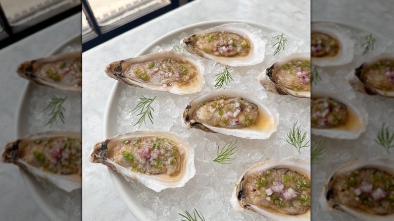 Oysters, shallots, and green herbs overtop ice