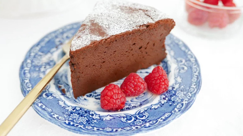 Chocolate sponge cake and raspberries on blue plate