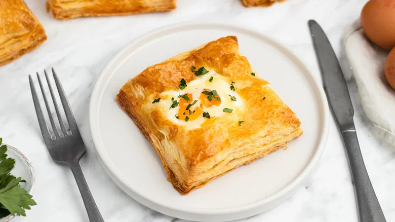 Savory pastry on white plate with silverware on table
