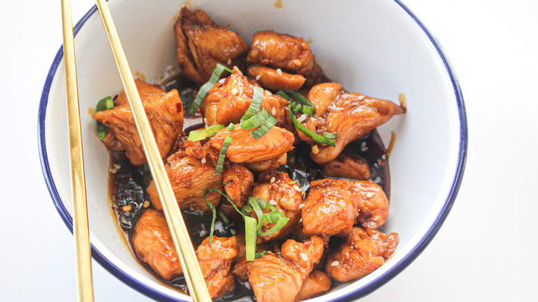 Teriyaki chicken in white bowl with chopsticks
