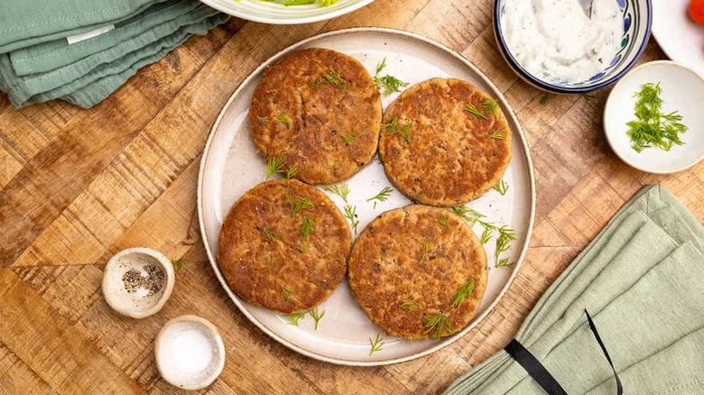 Tuna patties on white plate with dill sprinkled on top