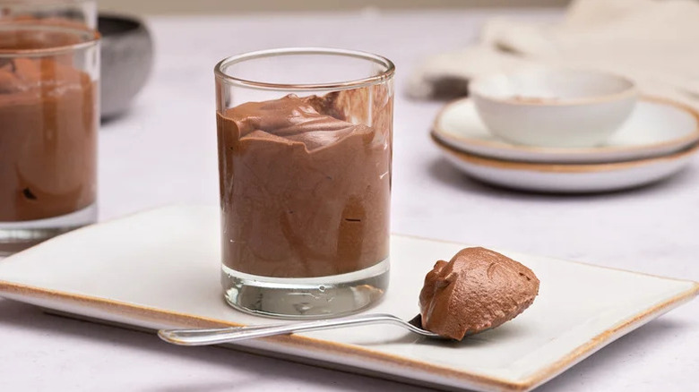 Chocolate mousse in clear glass on white plate