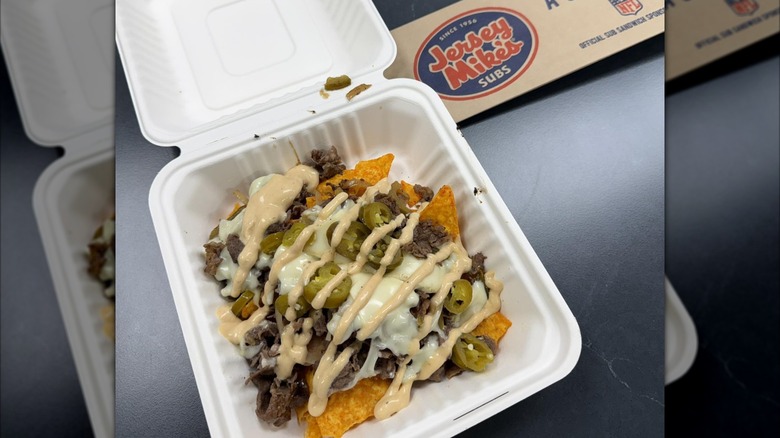 Jersey Mike's nachos with Doritos, meat, jalapenos, cheese, and mayo in white takeout box